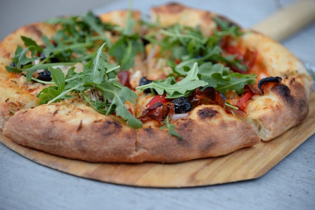 Pizza tout juste sortie du four — croûte dorée, roquette fraîche